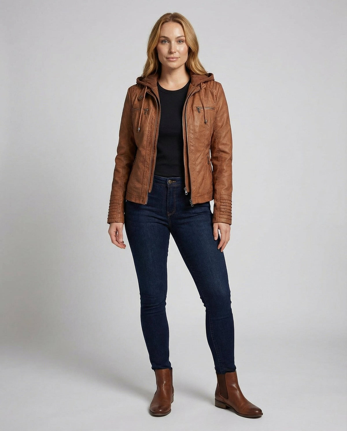 Model i cognacfarvet kunstlæderjakke og jeans, hel figur